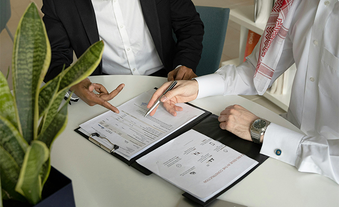 Deux personnes signant des documents pour une transaction immobilière